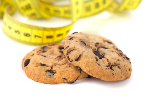 istock Chocolate Chip Cookie  with Measuring Tape Isolated on White, Diet Concept 1129675509