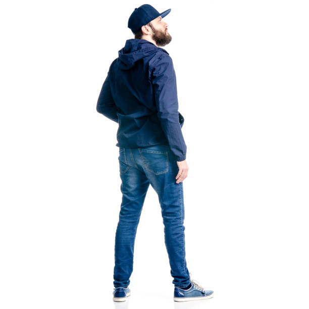 A man in jeans and jacket standing looking