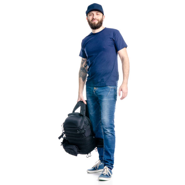 istock A man photographer in jeans and cap, black backpack standing looking 1129675842