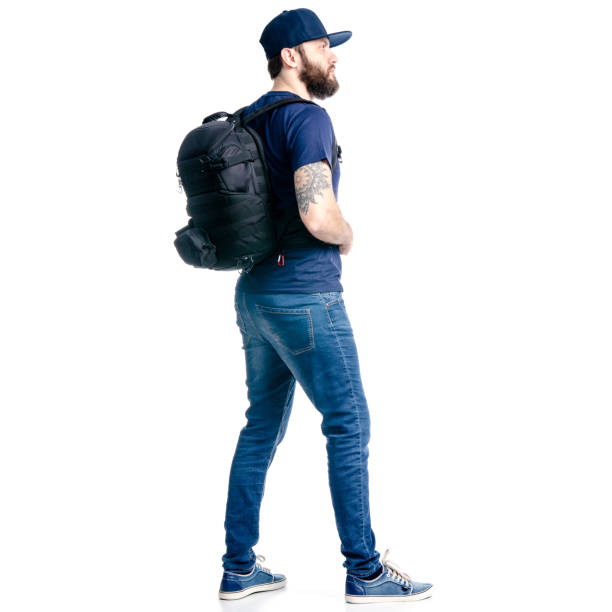 istock A man photographer in jeans and cap, black backpack goes walking looking 1129675847