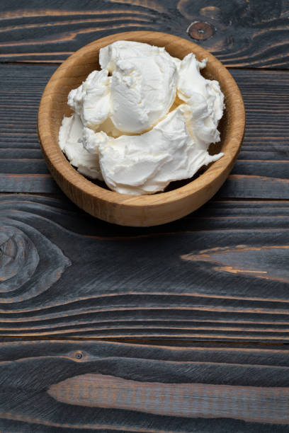 istock Traditional Mascarpone cheese in wooden bowl on table 1129676471