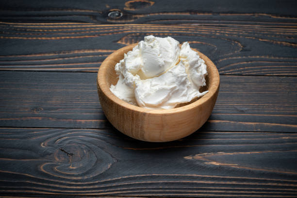 istock Traditional Mascarpone cheese in wooden bowl on table 1129676477