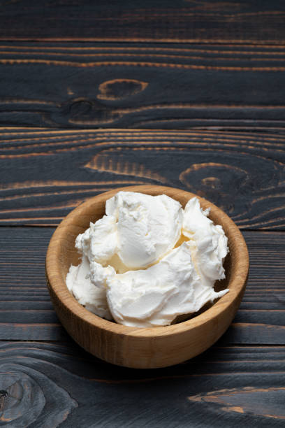 istock Traditional Mascarpone cheese in wooden bowl on table 1129676478