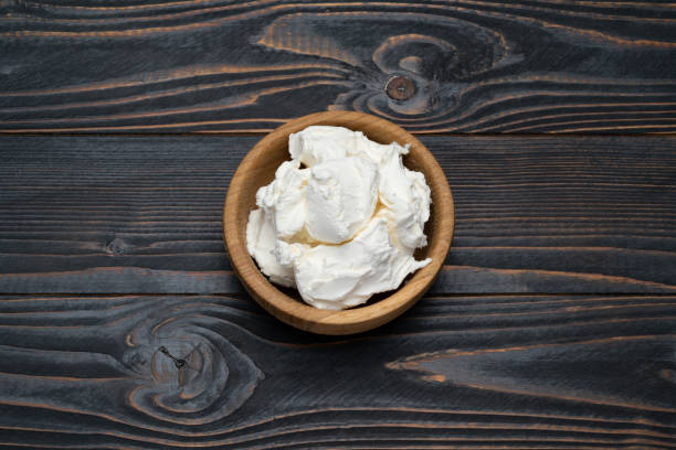 istock Traditional Mascarpone cheese in wooden bowl on table 1129676488