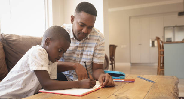 istock African American father helping his son with homework at table 1129676605