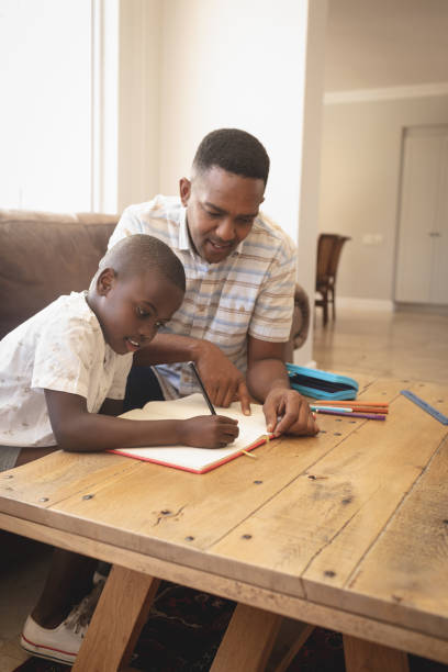 istock African American father helping his son with homework at table 1129676631