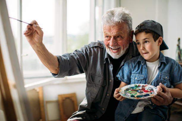 istock Kid and grandparent painting 1129676679