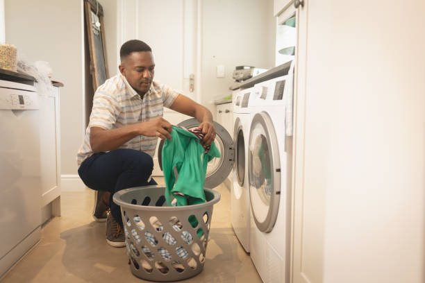 istock African American man washing clothes in washing machine 1129676744