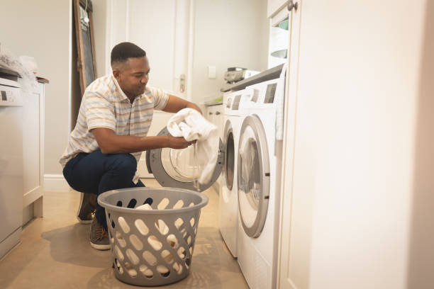 istock African American man washing clothes in washing machine 1129676768