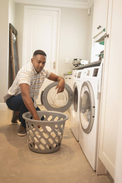 istock African American man washing clothes in washing machine 1129676800