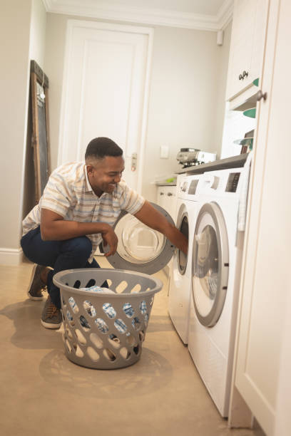 istock African American man washing clothes in washing machine 1129676821