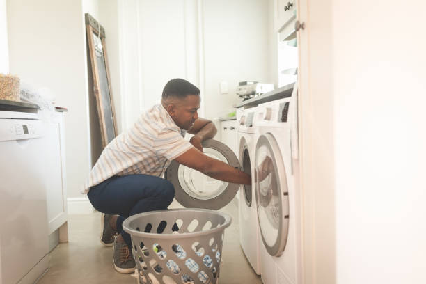 istock African American man washing clothes in washing machine 1129676844