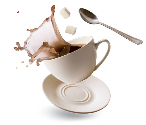 istock Falling Cup with coffee splash, cubes of refined sugar and teaspoon on a white 1129676959