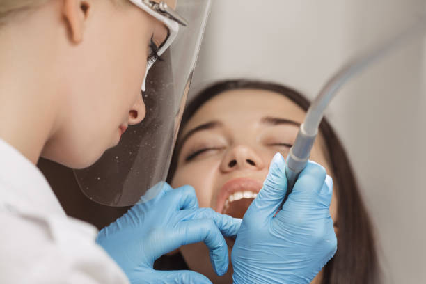 istock Dentist doing a dental treatment on a female patient. 1129678288