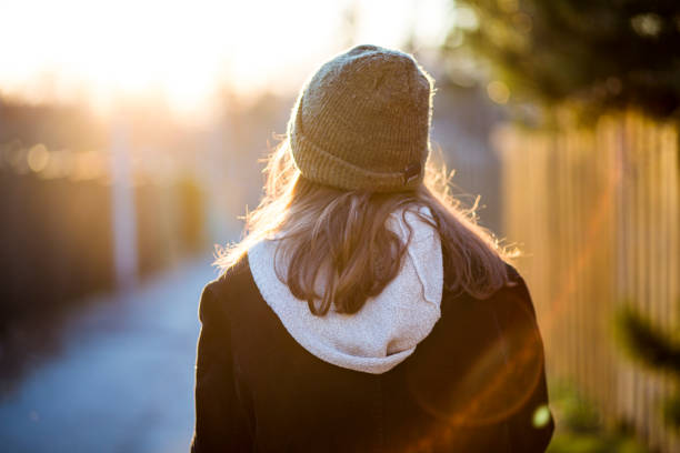 istock Rear view of a young woman at sunset 1129678414