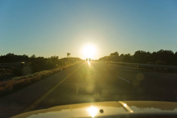 istock Semi-trucks driving on highway seen through windshield of car at sunset 1129678515