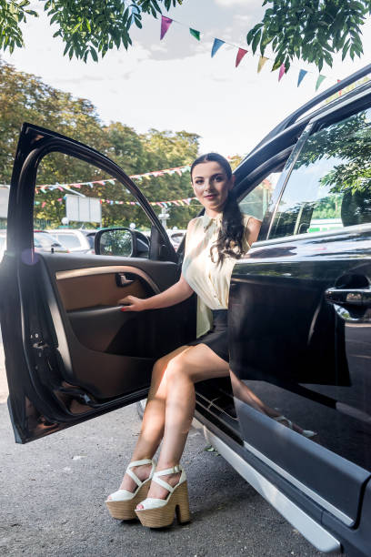 istock Beautiful brunette posing with car holding legs outside 1129679236