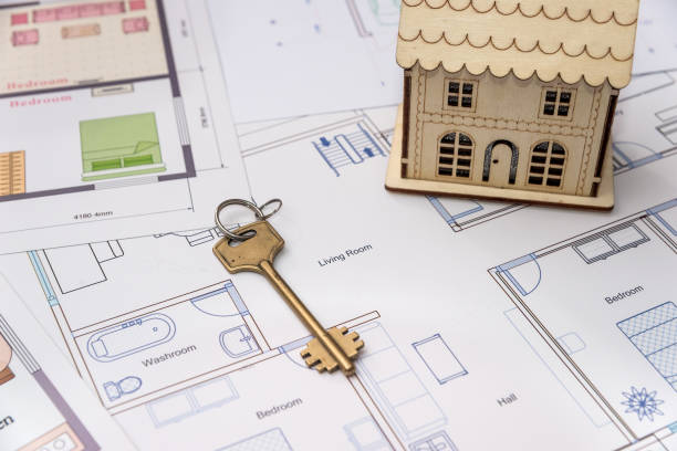istock Wooden house model with key on house plan 1129679731