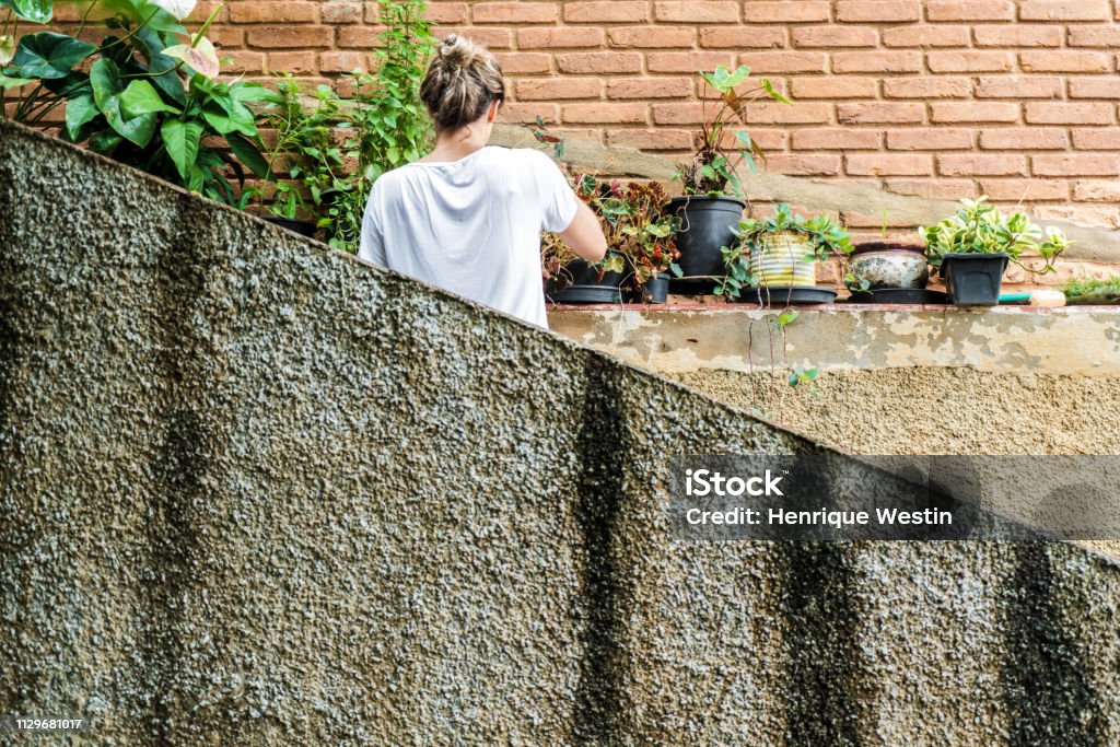 Young blond woman in her 30s taking care of the garden 30-39 Years Stock Photo