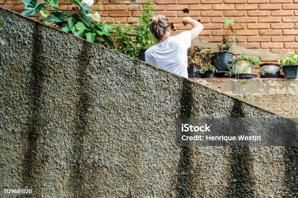 Young Blond Woman In Her 30s Taking Care Of The Garden Stock Photo - Download Image Now