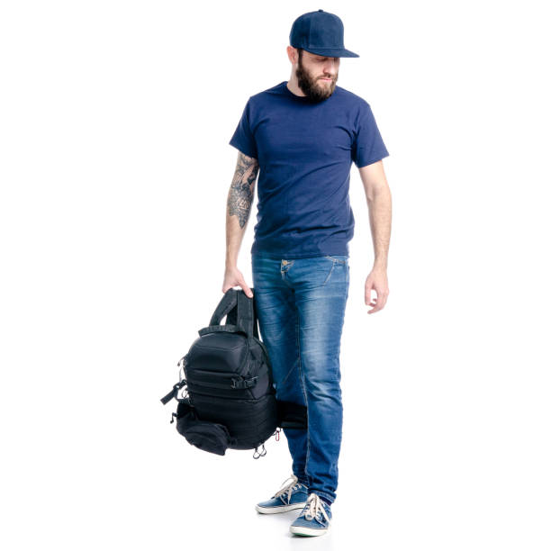 istock A man photographer in jeans and cap, black backpack standing looking 1129681113