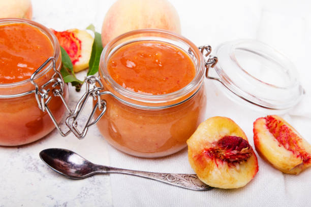 homemade peach jam with organic fruit. sweet preserves on a light background, copy space - preserves jar apricot marmalade imagens e fotografias de stock