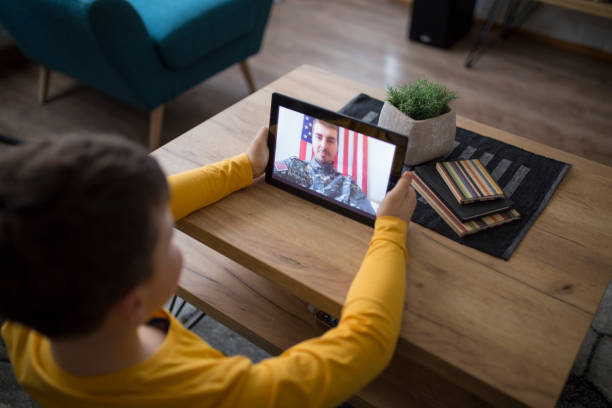 istock Son video chats with his father in military 1129687711