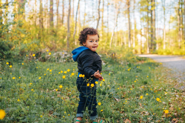 istock Adorable african toddler boy hiking in spring forest 1129691925