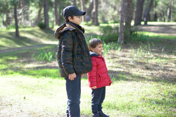istock Happy brothers playing in forest sunny day 1129693015