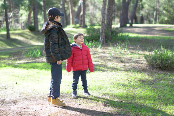 istock Happy brothers playing in forest sunny day 1129693246