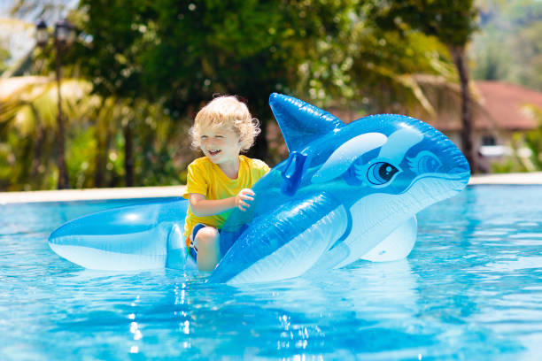istock Child in swimming pool. Kid on inflatable float 1129696186