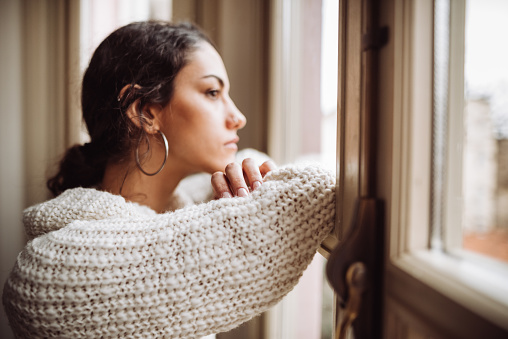 mujer pensativa frente a la ventana photo