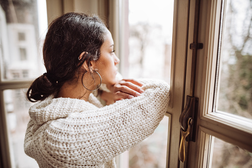 mujer pensativa frente a la ventana photo