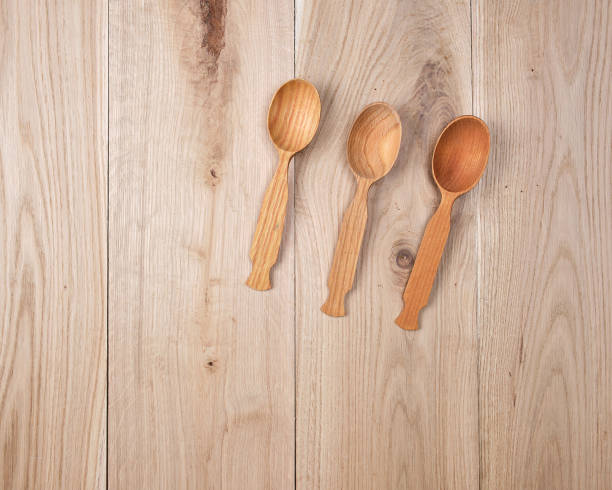 istock three empty wooden spoons on a background of oak boards 1129698012