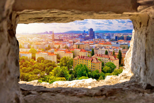 istock Vienna cityscape and sun haze view through stone window 1129700892