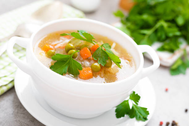 istock Summer light vegetarian vegetable soup with carrot, potato, cabbage and grean peas on white background. Diet healthy and tasty lunch. Baby food 1129701226