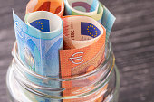 Glass jar with euro bills close-up.