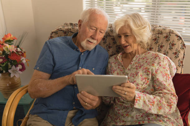 istock Senior couple using digital tablet in living room 1129703875