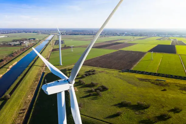 Photo of Windmills / wind turbines providing eco friendly renewable energy from sustainable resources. Near Waalwijk, Noord Brabant, Netherlands.