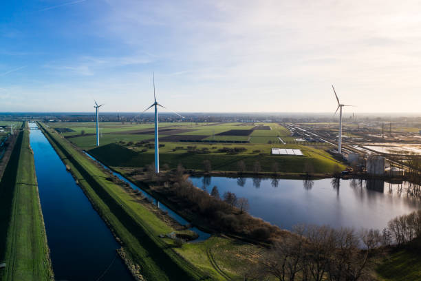 Windmills next to the water seen from a birds eye view in Waalwijk, Noord Brabant, Netherlands. Wind turbines generating green energy. berkel stock pictures, royalty-free photos & images