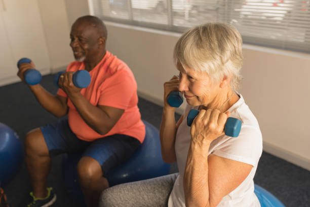 istock Senior people exercising with dumbbells at home 1129705090