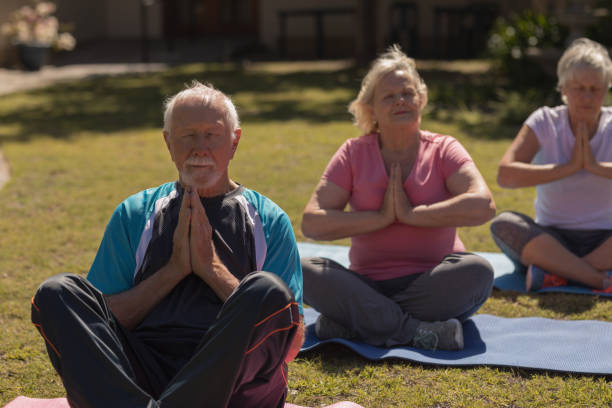 istock Senior people performing yoga in the park 1129705227