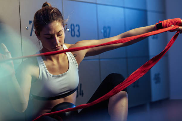 istock Young athletic woman bandaging her hands before boxing training. 1129706884