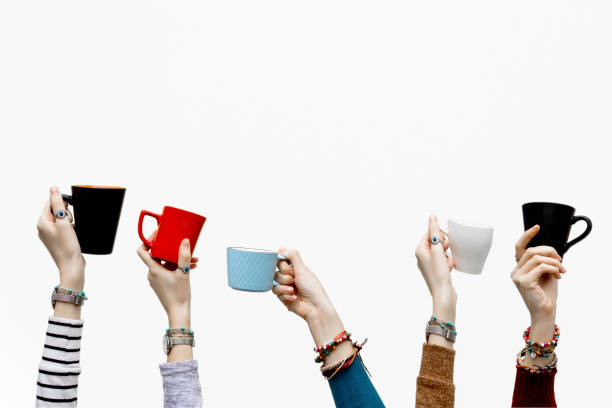 istock Many different hands holding coffee cups on isolated white background. 1129707060