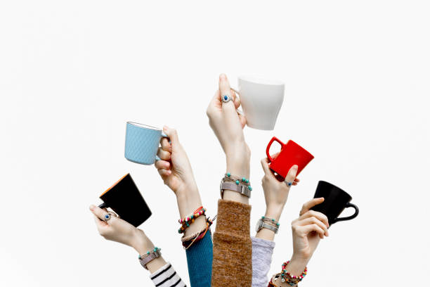 istock Many different hands holding coffee cups on isolated white background. 1129707102