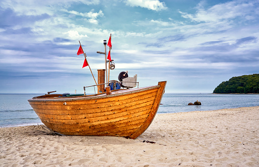 Old wooden fishing boat on sandy beach in the Baltic Sea resort of Binz. Island Rügen, Germany