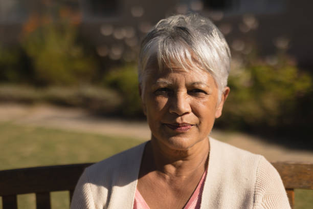 istock Senior woman sitting on a bench in the park 1129711603
