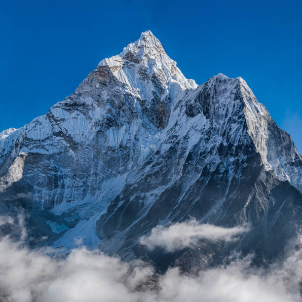 Panorama of beautiful  Mount Ama Dablam in  Himalayas, Nepal XXXXL size panorama of Mount Ama Dablam - probably the most beautiful peak in Himalayas. 
 This panoramic landscape is an very high resolution multi-frame composite and is suitable for large scale printing
Ama Dablam is a mountain in the Himalaya range of eastern Nepal. The main peak is 6,812  metres, the lower western peak is 5,563 metres. Ama Dablam means  'Mother's neclace'; the long ridges on each side like the arms of a mother (ama) protecting  her child, and the hanging glacier thought of as the dablam, the traditional double-pendant  containing pictures of the gods, worn by Sherpa women. For several days, Ama Dablam dominates  the eastern sky for anyone trekking to Mount Everest basecamp Icefall stock pictures, royalty-free photos & images