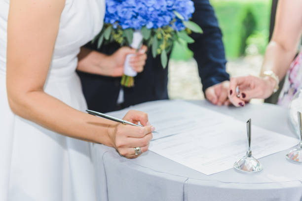 結婚式の日。花嫁が結婚証明書にサインします。 - civilian ストックフォトと画像