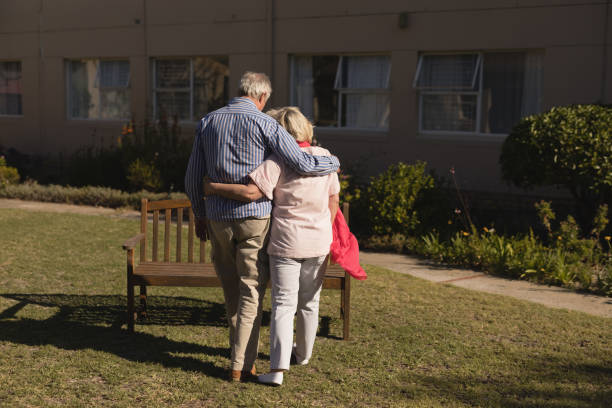 istock Senior couple standing with arm around in the park 1129714109